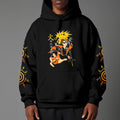 Black pullover hoodie featuring Naruto Uzumaki portrait on chest and vertical orange Japanese Kanji text on sleeves, worn by model on grey background.