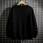 Black crewneck sweatshirt featuring two vertically stacked circular Dragon Ball Z 'Go' Kanji symbols (one orange, one white), flat lay on grey background.