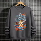 Black crewneck sweatshirt featuring Goku shadow silhouette with blue and pink neon aura and vertical Japanese text, flat lay on grey background.