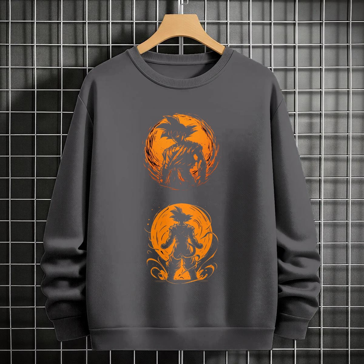 Black crewneck sweatshirt featuring Goku shadow silhouette with blue and pink neon aura and vertical Japanese text, flat lay on grey background.