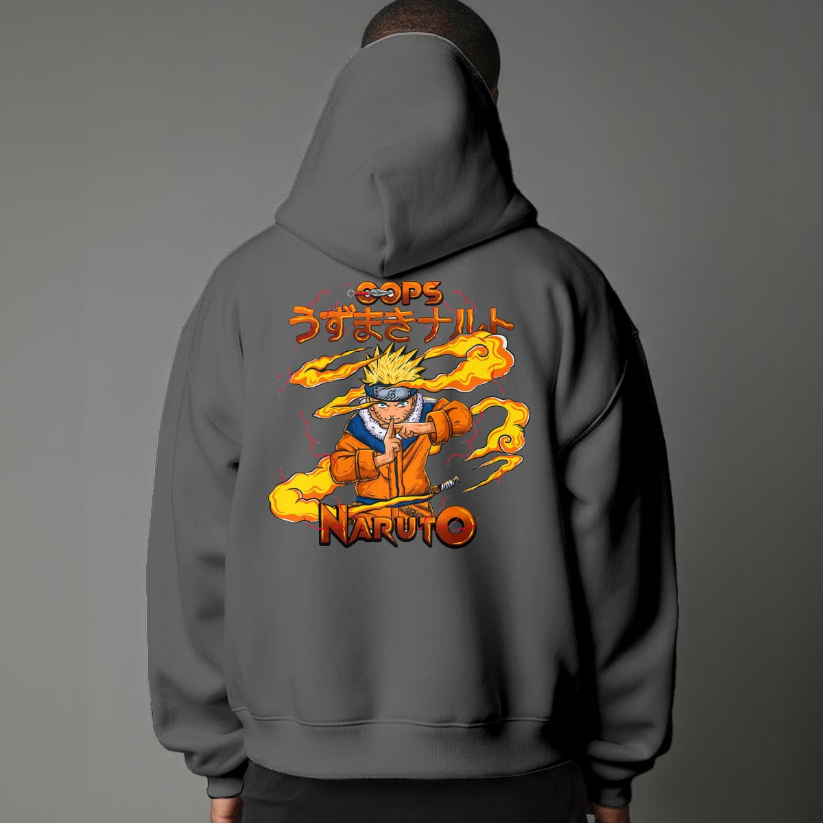 Black pullover hoodie featuring Naruto Uzumaki portrait on chest and vertical orange Japanese Kanji text on sleeves, worn by model on grey background.