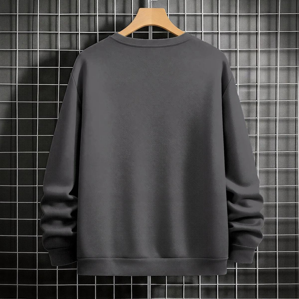 Black crewneck sweatshirt featuring two vertically stacked circular Dragon Ball Z 'Go' Kanji symbols (one orange, one white), flat lay on grey background.